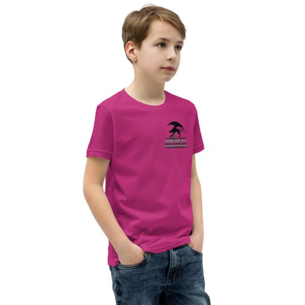 A young boy wearing a pink shirt and jeans.