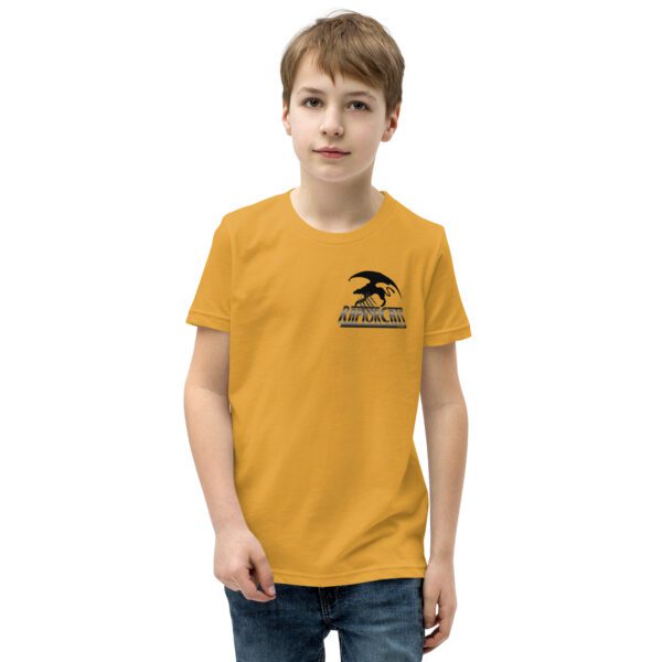 A boy wearing a yellow t-shirt with an eagle on the front.