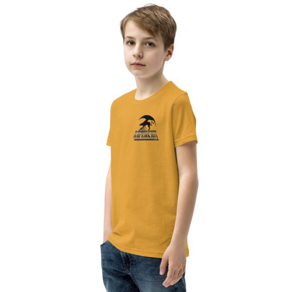 A boy wearing a yellow t-shirt with an image of a tree.