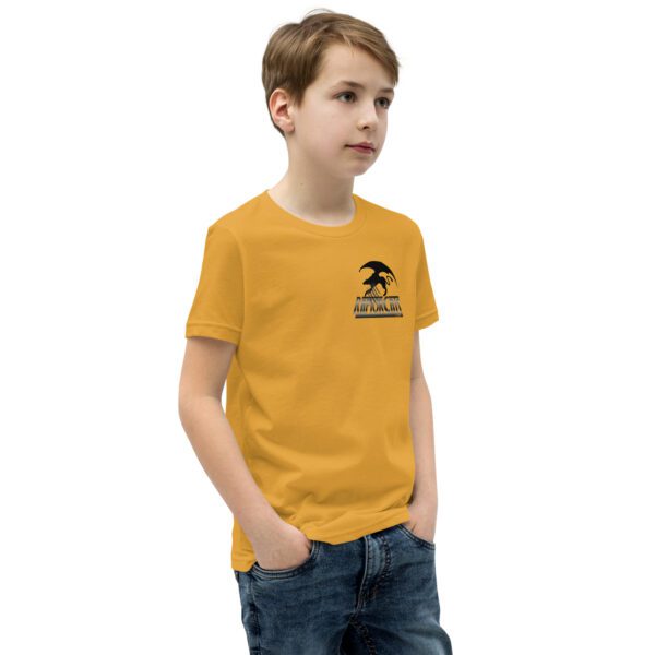 A boy wearing a yellow t-shirt with an image of a person on it.