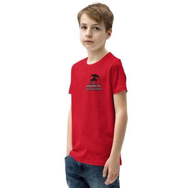 A boy wearing a red shirt and jeans.