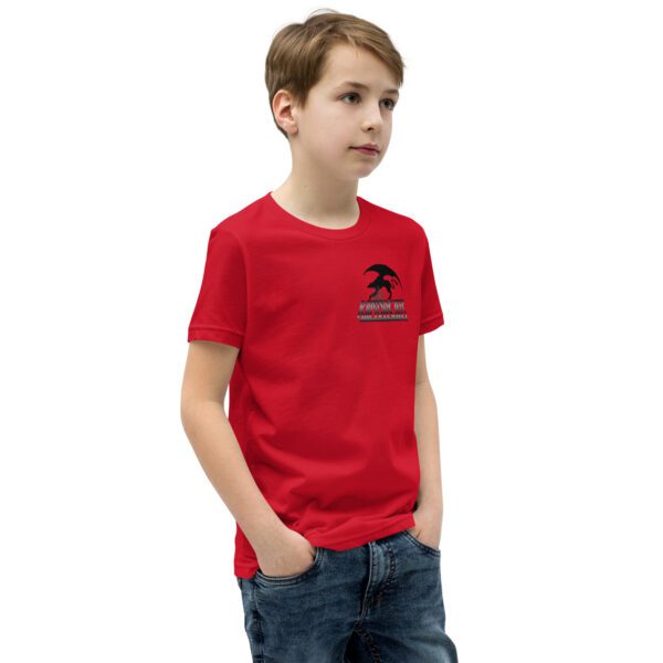 A boy wearing a red shirt and jeans.