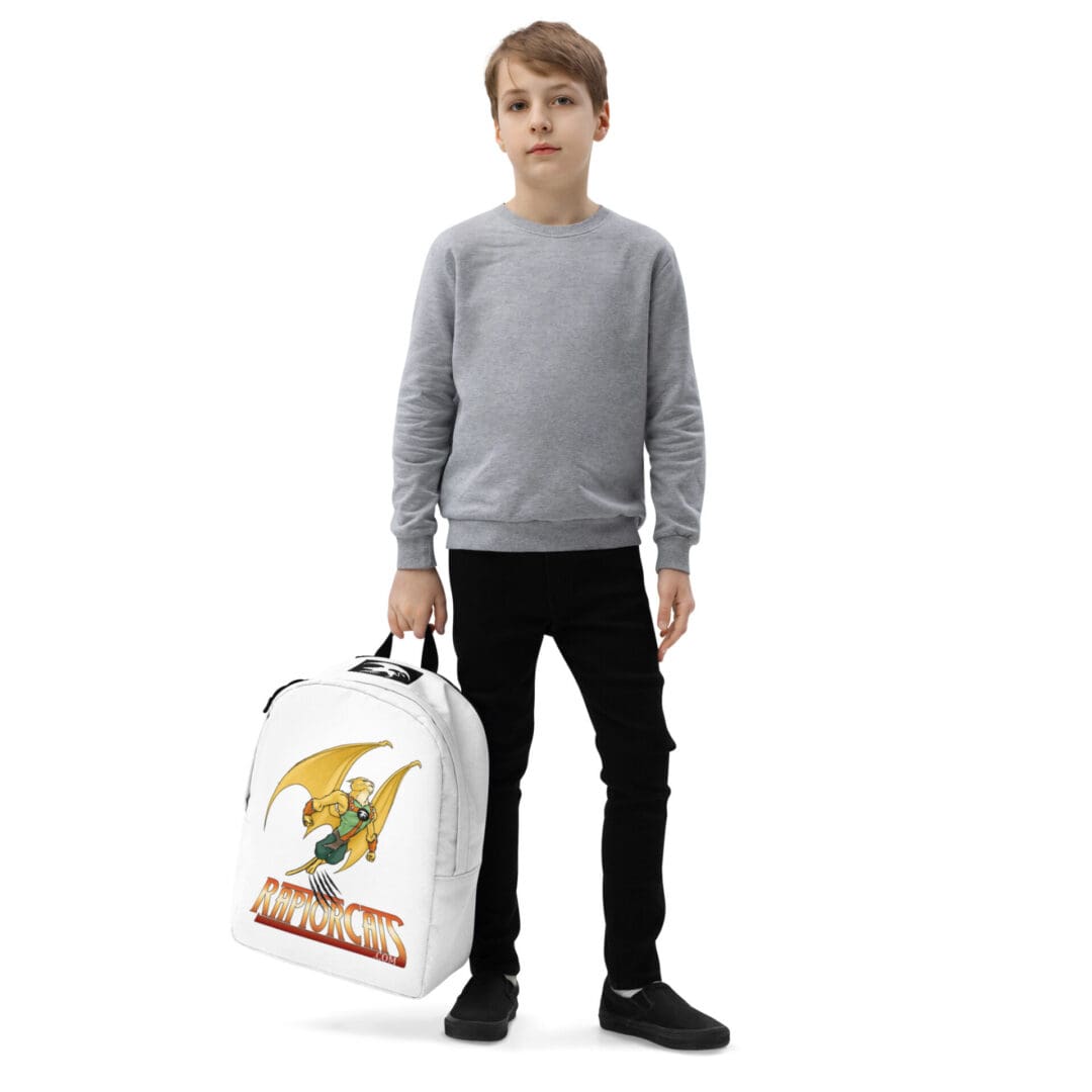 Boy holding backpack with cartoon design.