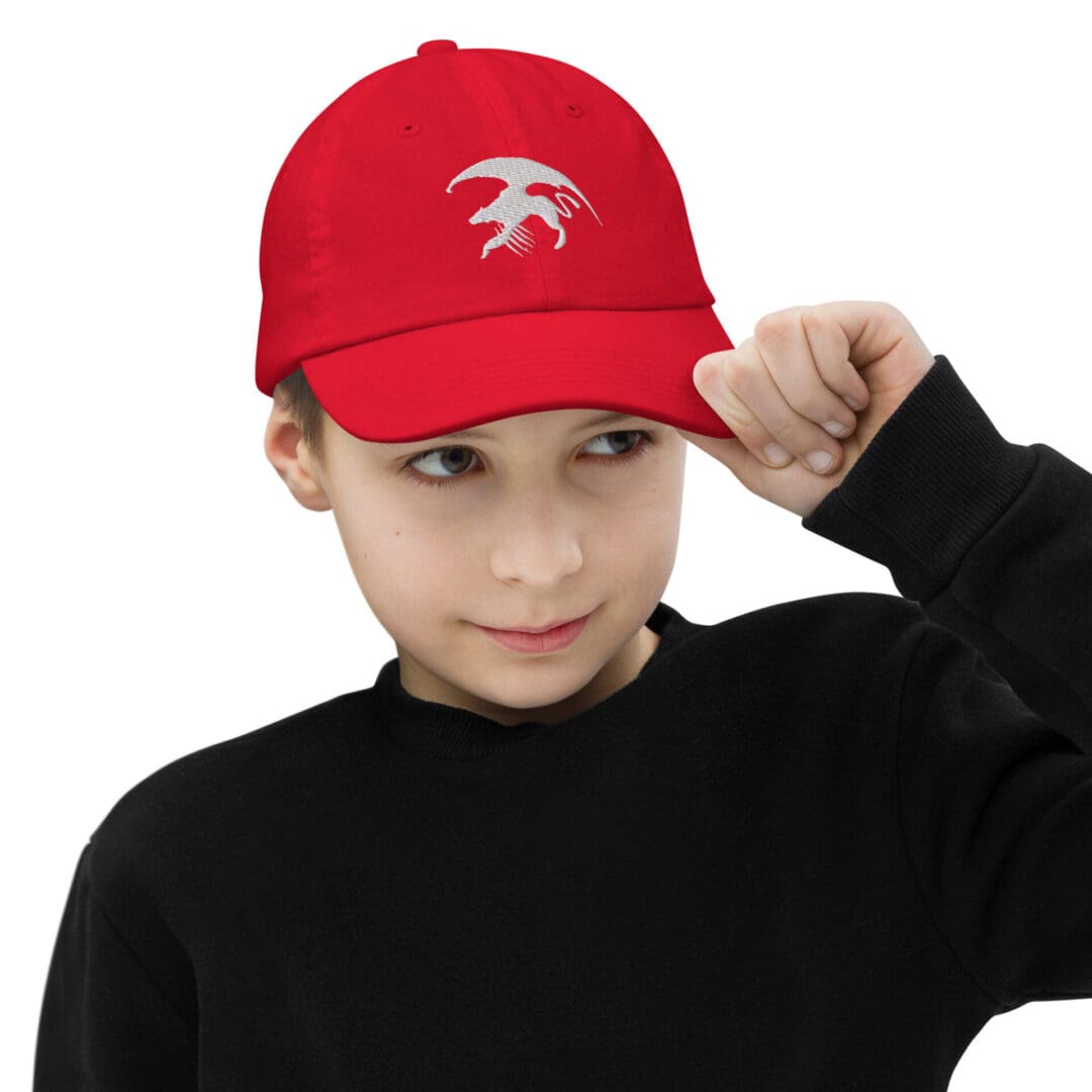 Child wearing red cap with white logo.