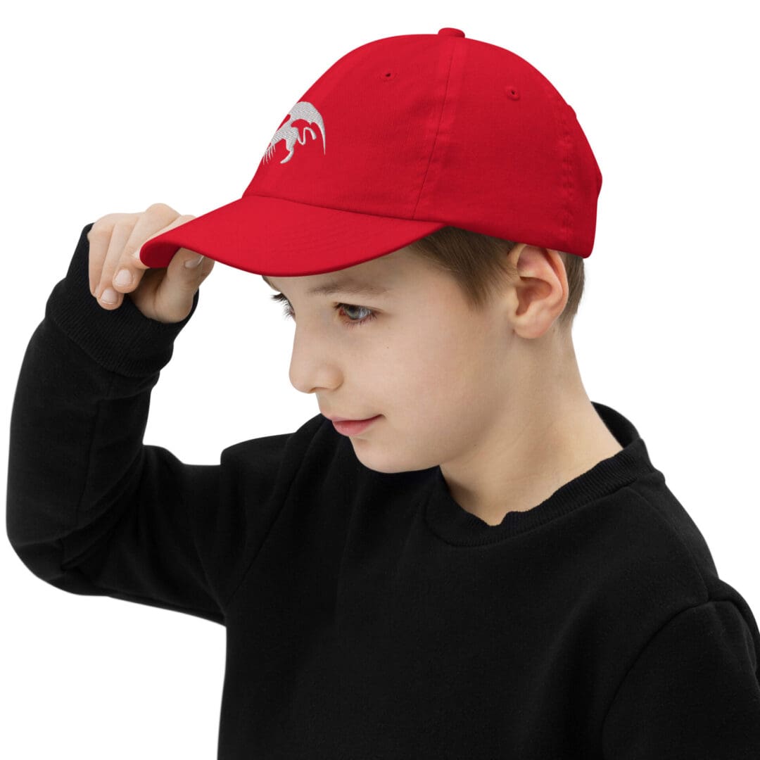 Child wearing red cap with dragon logo.
