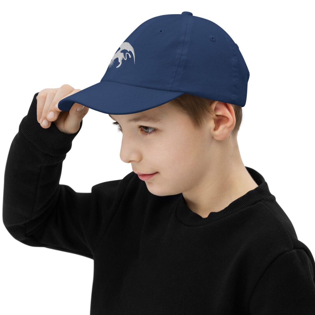 Child wearing blue cap with white emblem.